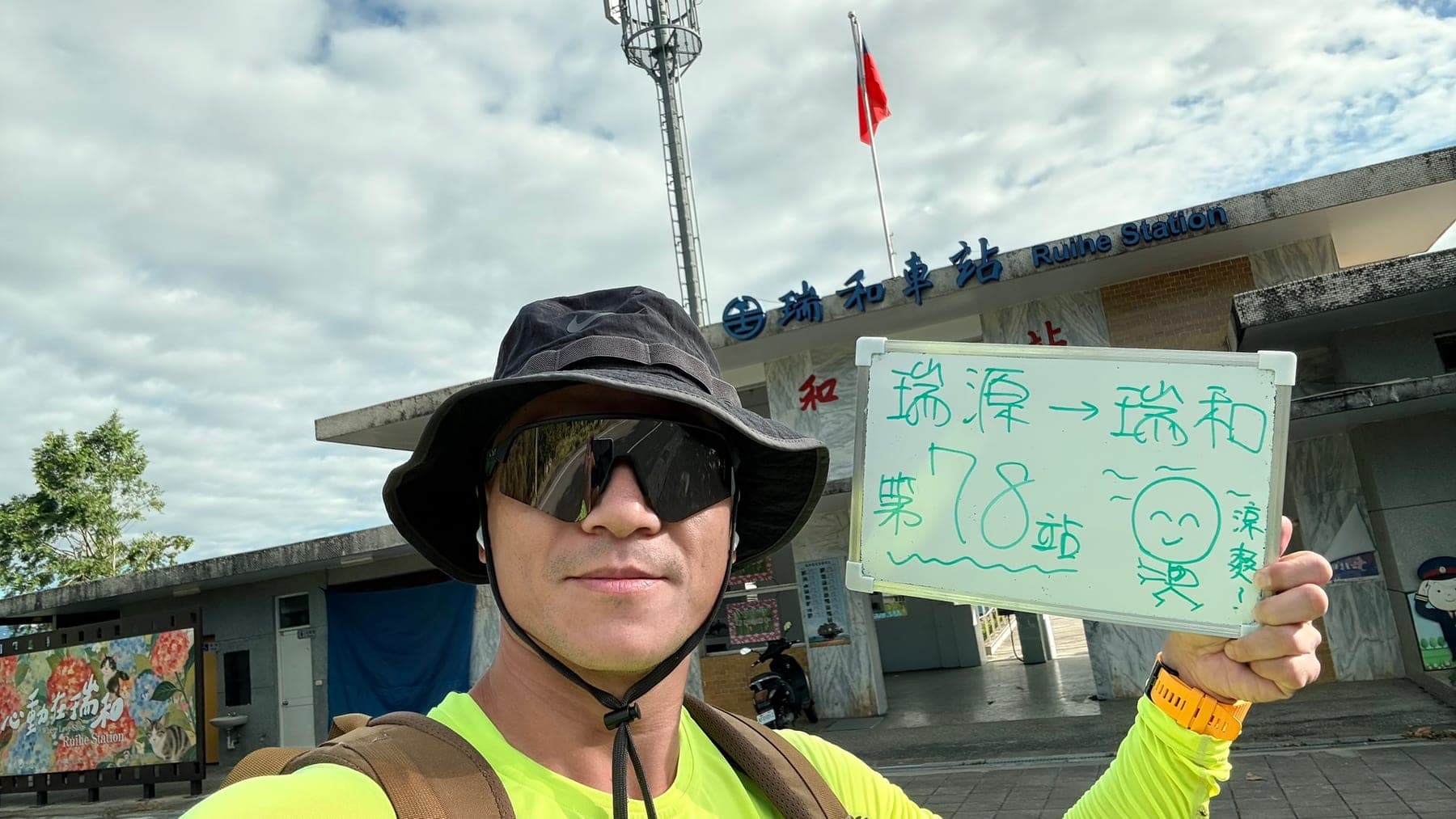 站主在瑞和站站牌前的走訪紀錄照，手持寫著「徒步環島 第 78 站　瑞源 → 瑞和」的白板