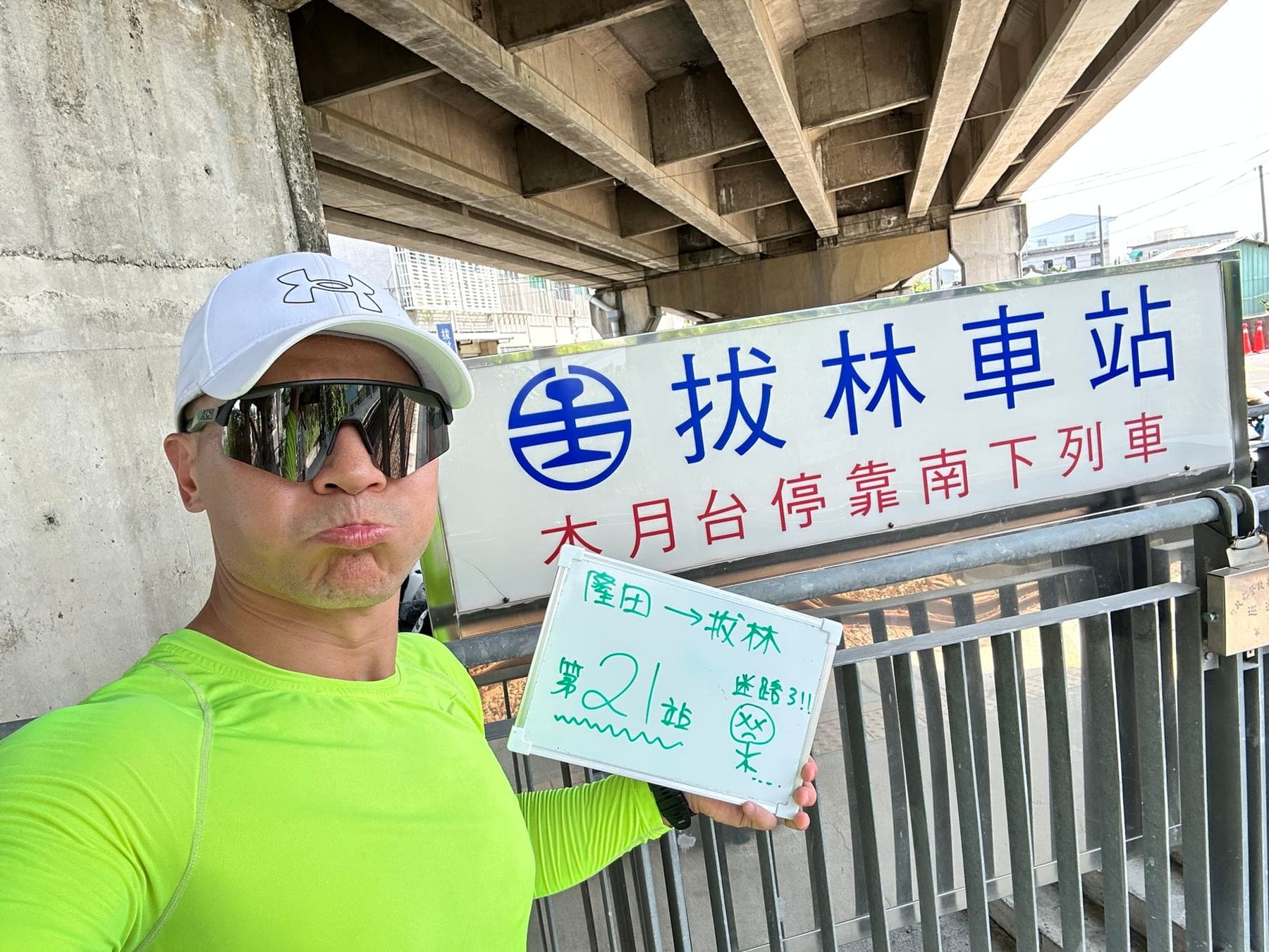 站主在拔林站站牌前的走訪紀錄照，手持寫著「徒步環島 第 21 站　隆田 → 拔林」的白板
