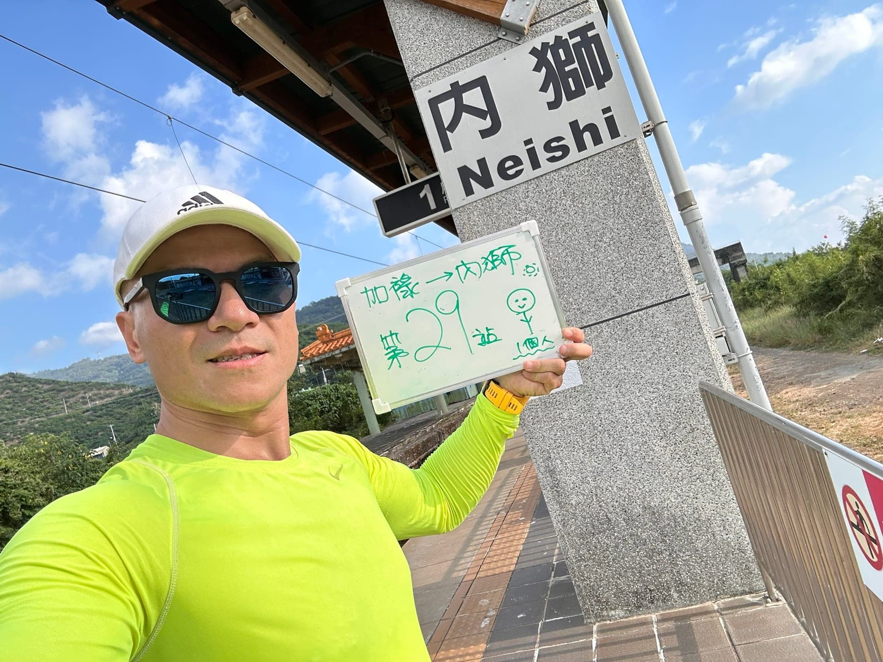 站主在內獅站站牌前的走訪紀錄照,手持寫著「徒步環島 第 29 站 加祿 → 內獅」的白板