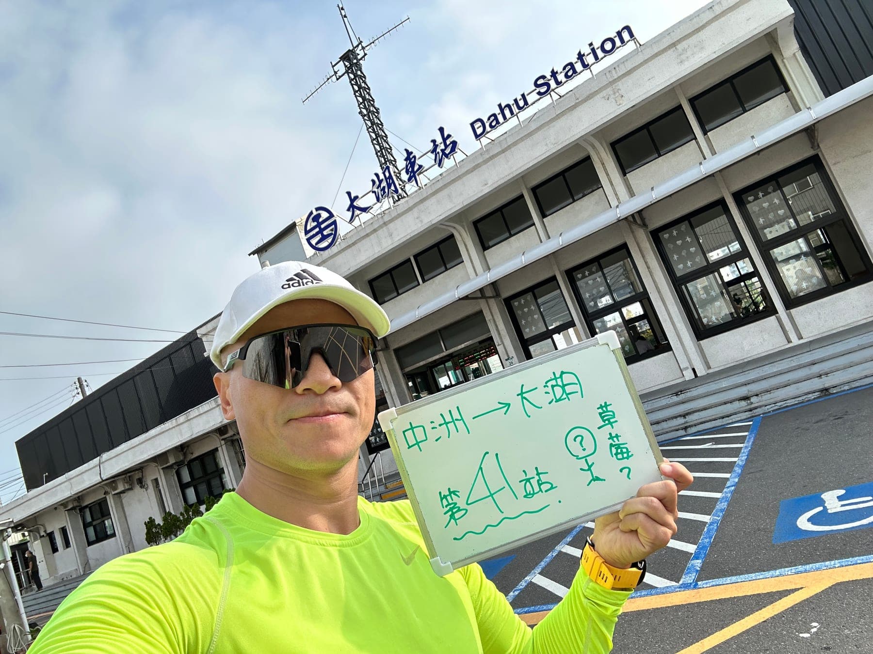 站主在大湖站站牌前的走訪紀錄照,手持寫著「徒步環島 第 41 站 中洲 → 大湖」的白板