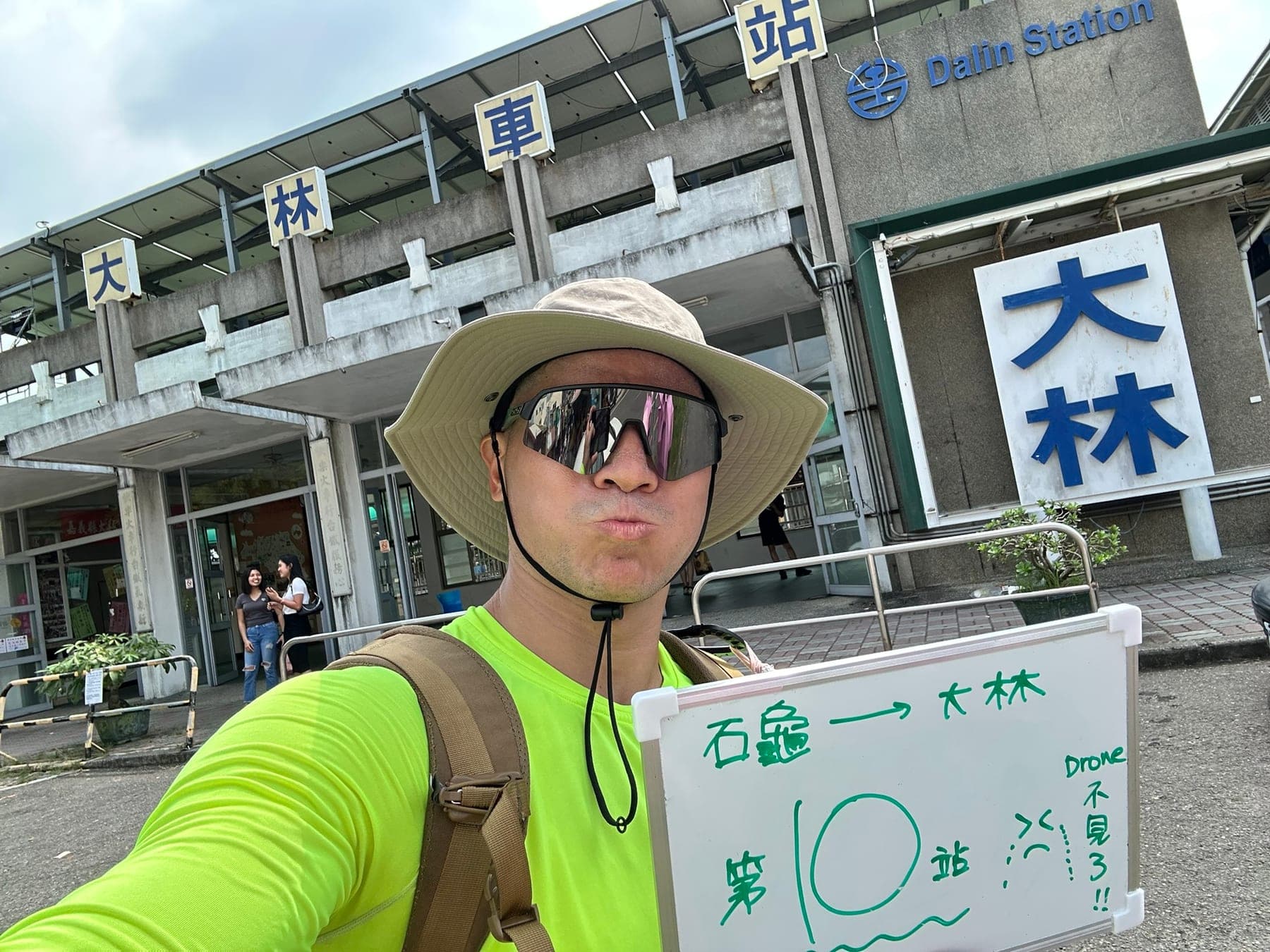 站主在大林站站牌前的走訪紀錄照,手持寫著「徒步環島 第 10 站 石龜 → 大林」的白板