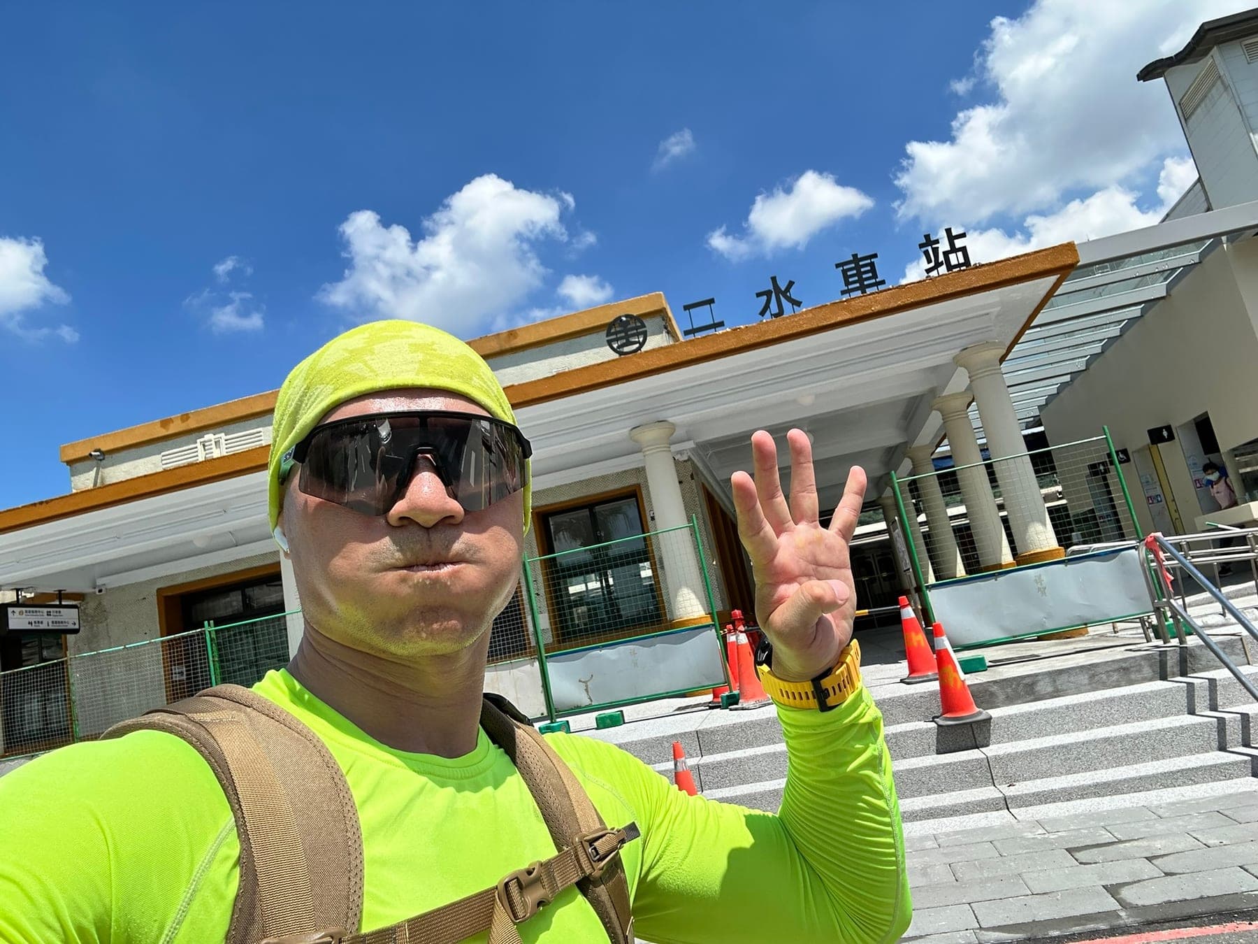 站主在二水車站前的走訪紀錄照,手比四代表第 4 站,身後是白色列柱的舊站房