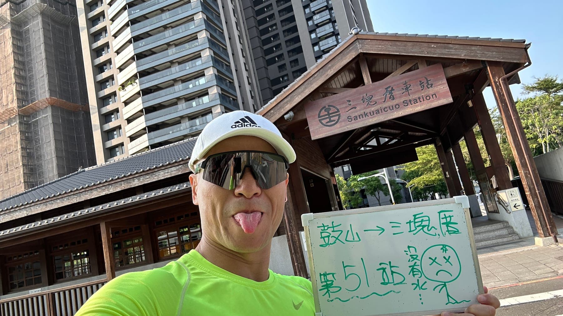 站主在三塊厝站站牌前的走訪紀錄照,手持寫著「徒步環島 第 51 站 鼓山 → 三塊厝」的白板