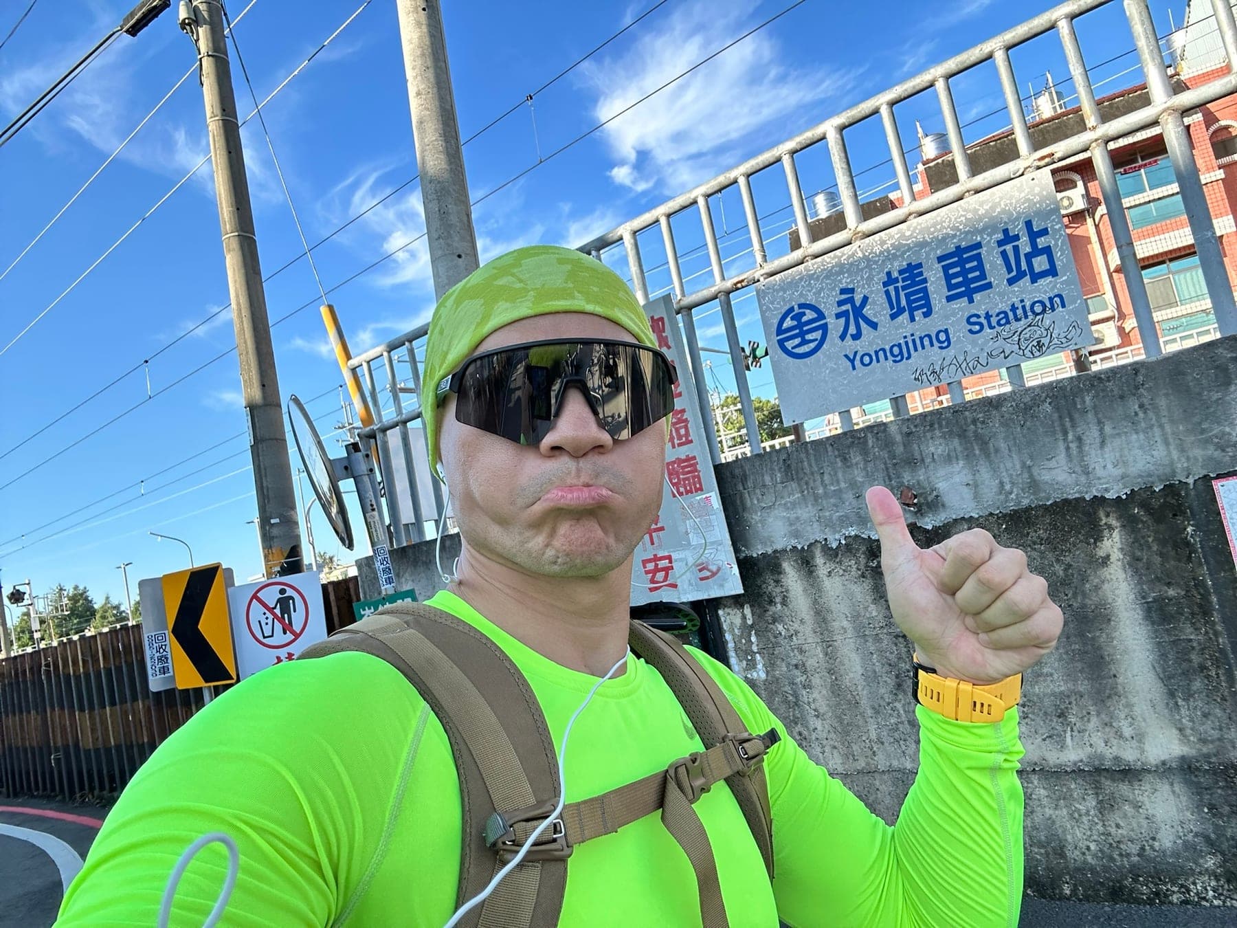站主在永靖車站站牌前的走訪紀錄照,比出一個大拇指代表第 1 站